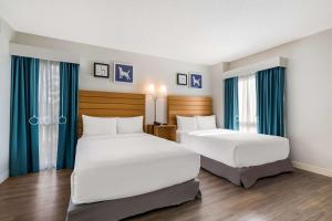 奥兰多奥兰多国际大道索奈斯特ES套房酒店的两张位于酒店客房的床,配有蓝色窗帘