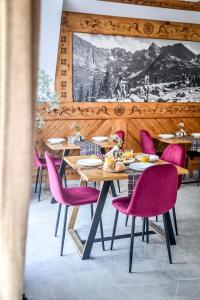 斯扎法拉瑞Cicha Woda 300 m od Gorący Potok i Termy Szaflary的用餐室配有桌子和粉红色的椅子