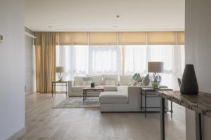 迪拜Nasma Luxury Stays - City Walk Building 5的客厅配有白色沙发和一些窗户。
