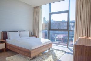 迪拜Nasma Luxury Stays - City Walk Building 5的一间卧室设有一张床和一个大窗户