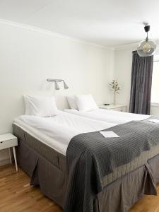穆尔舍Mullsjö Hotell & Konferens的一间卧室配有一张带白色床单的大床