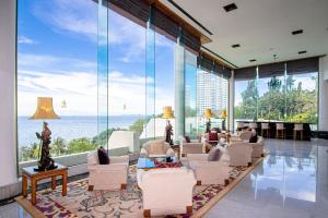 南芭堤雅Royal Wing Suites & Spa Pattaya的客厅设有大型玻璃墙