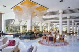 南芭堤雅Royal Wing Suites & Spa Pattaya的大型大堂设有白色家具和大吊灯