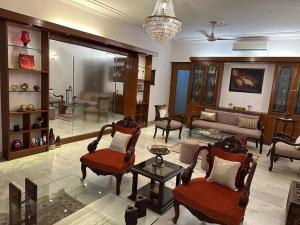 新德里PRESTIGE Greater Kailash Part 1的一个带椅子和沙发的大客厅