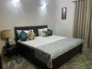 新德里PRESTIGE Greater Kailash Part 1的卧室内的一张带枕头的床