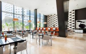瓦伦西亚伊鲁尼阿夸3号酒店的餐厅设有桌椅和窗户。