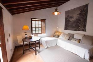 拉拉古纳Casa rural cerca de la costa de La Laguna 2的客厅配有两张床和一张桌子