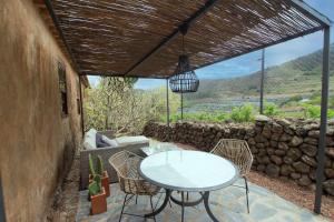 拉拉古纳Casa rural cerca de la costa de La Laguna 2的一个带桌椅和石墙的庭院