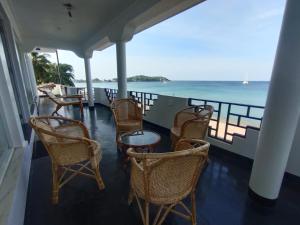 亭可马里Sellamah beach Hotel的一个带桌椅的海景阳台