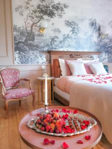 蒙特里夏尔Domaine Le Clos de la Source - Petit déjeuner buffet的一间设有两张床的客房和一张桌子上的水果盘