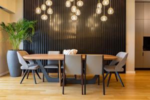塞萨洛尼基ICONIC SALONICA SUITE seafront的一间带木桌和椅子的用餐室