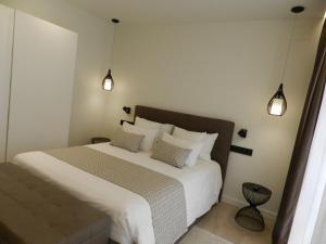 马尔托雷尔HOTEL MANEL的卧室配有一张带两个枕头的大白色床
