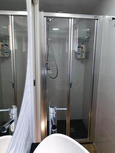 圣波拉Apartamento Caravaca的浴室设有玻璃淋浴间和卫生间