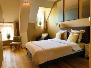 Les Champs-GérauxLe Manoir des Haies的一间卧室设有一张大床和一个窗户。