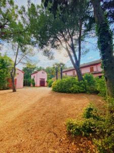 Case Selva GrandeCasal Camillo的一座大院子,有树木和粉红色的建筑