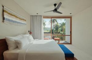 塞隆贝拉纳克Boni Beach Lombok Boutique Hotel的一间带白色床的卧室和一个阳台
