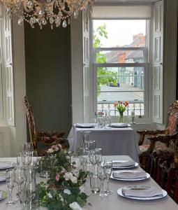 邓甘嫩Charlemont House的用餐室配有带玻璃杯和鲜花的桌子