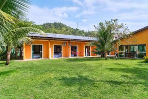 乌巴图巴Pousada Villa Piemonte的一座种植了棕榈树的橙色建筑