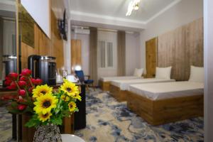 TürkistanAlmaty City的酒店客房带两张床和花瓶