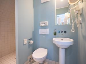 科隆科隆会展中心纽约人酒店的浴室配有白色卫生间和盥洗盆。