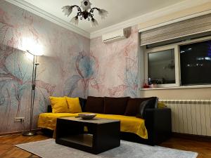 SajmišteApartman Sasha 1的客厅设有黄色的沙发和色彩缤纷的墙壁