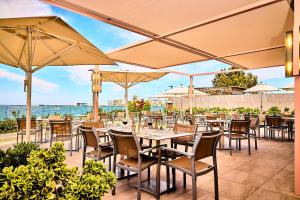 圣安东尼奥湾NYX Hotel Ibiza by Leonardo Hotels-Adults Only的一间带桌椅和遮阳伞的餐厅