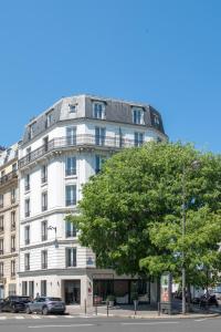 巴黎Hôtel Coypel by Magna Arbor的前面有棵树的白色建筑