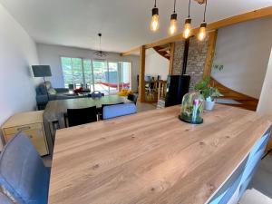 PublierMaison familiale vue lac avec jardin - à 10mn du lac et stations de ski的厨房以及带木桌的起居室。