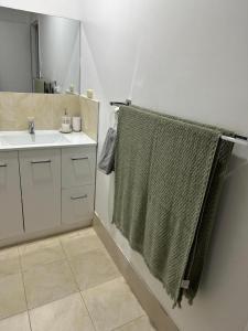 珀斯Cozy Inn的一间带水槽和绿毛巾的浴室
