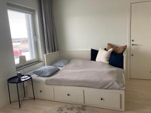 马尔默Hyllie Appartement - New Construction的卧室配有带枕头的床铺和窗户。