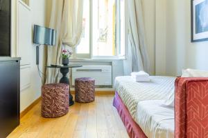 博洛尼亚Casa Hygiea in Canton De' Fiori的酒店客房带一张床和两张凳子