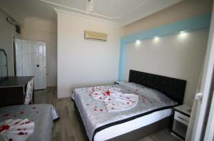 菲尼凯Deniz Hotel的一间卧室,床上有红色的鲜花