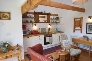 彻奇斯特雷顿Nest Holiday Hideaway Wren Cottage Stunning Area!的厨房配有白色橱柜和桌椅