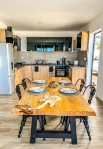 珀蒂蒂勒Villa cap sud and spa 1的厨房配有木桌、椅子和桌子。