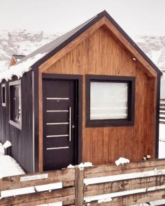厄尔查尔坦Patagonia Tiny House的小木屋,雪中设有黑色门