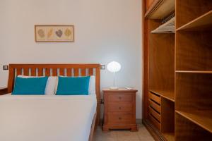 卡门港Sabbia Suites Sea View La Playita的一间卧室配有一张带蓝色枕头的床和梳妆台