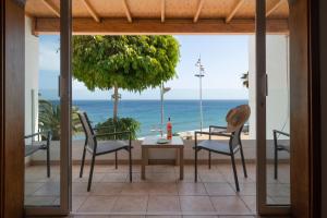 卡门港Sabbia Suites Sea View La Playita的一个带桌椅的庭院和大海