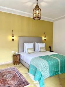 马拉喀什Riad Deha & Spa的卧室配有一张带吊灯的大型白色床。