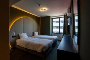 亨克格林酒店的酒店客房设有两张床和窗户。