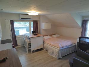 赫尔辛基Kalle's unluxury guest house Aircon 15min city center by train的一间小卧室,配有一张床和一张书桌