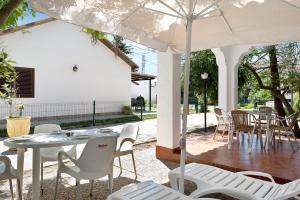 罗切Casa Paqui 1的庭院配有桌椅和遮阳伞。