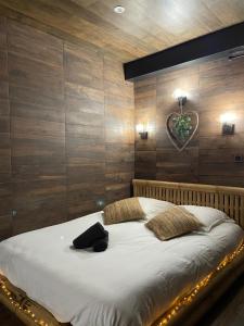 布瓦西圣雷热BY NEPTUNE - Appartement Indonésien的一间卧室配有一张带木墙的大床