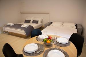 伊佐拉Dea Del Mar Apartments的一间设有两张床和一张带一碗水果的桌子的房间