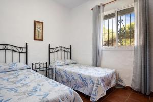 罗切Casa Paqui 3的一间卧室设有两张床和窗户。