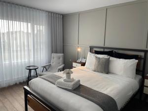 拜圣保罗Domaine Belle Plage的一间卧室配有一张大床和一把椅子