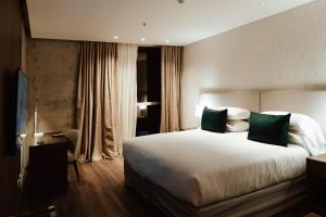 圣胡安Del Bono Central Hotel的酒店客房配有一张带绿色枕头的大床