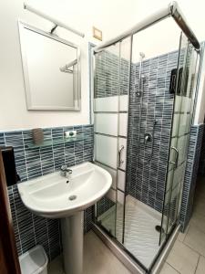 GibaLa Residenza B&B的一间带水槽和玻璃淋浴的浴室