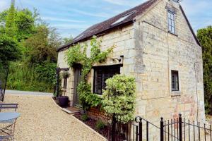 HarescombeMill House Cottage - Star Stay on The Cotswold Way的一座有常春藤的古老石头建筑