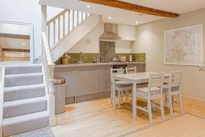 HarescombeMill House Cottage - Star Stay on The Cotswold Way的一间带桌椅和楼梯的厨房