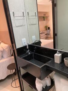 巴西利亚Flats Condomínio Park Ville by CentoEdez的浴室设有黑色水槽和镜子